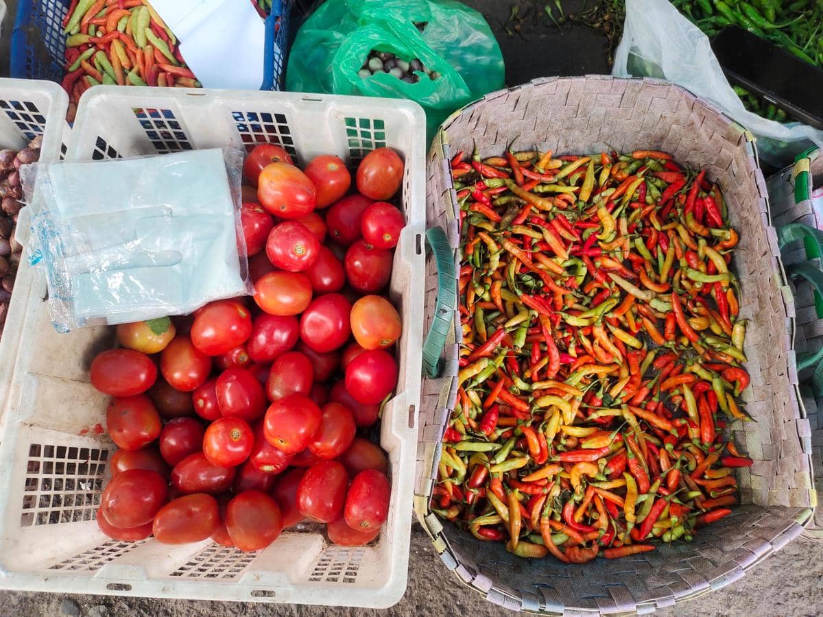 Aneka cabai merah dan tomat segar tersusun di lapak pedagang Pasar Pagi Setiabudi, Medan, dalam wadah jualan.