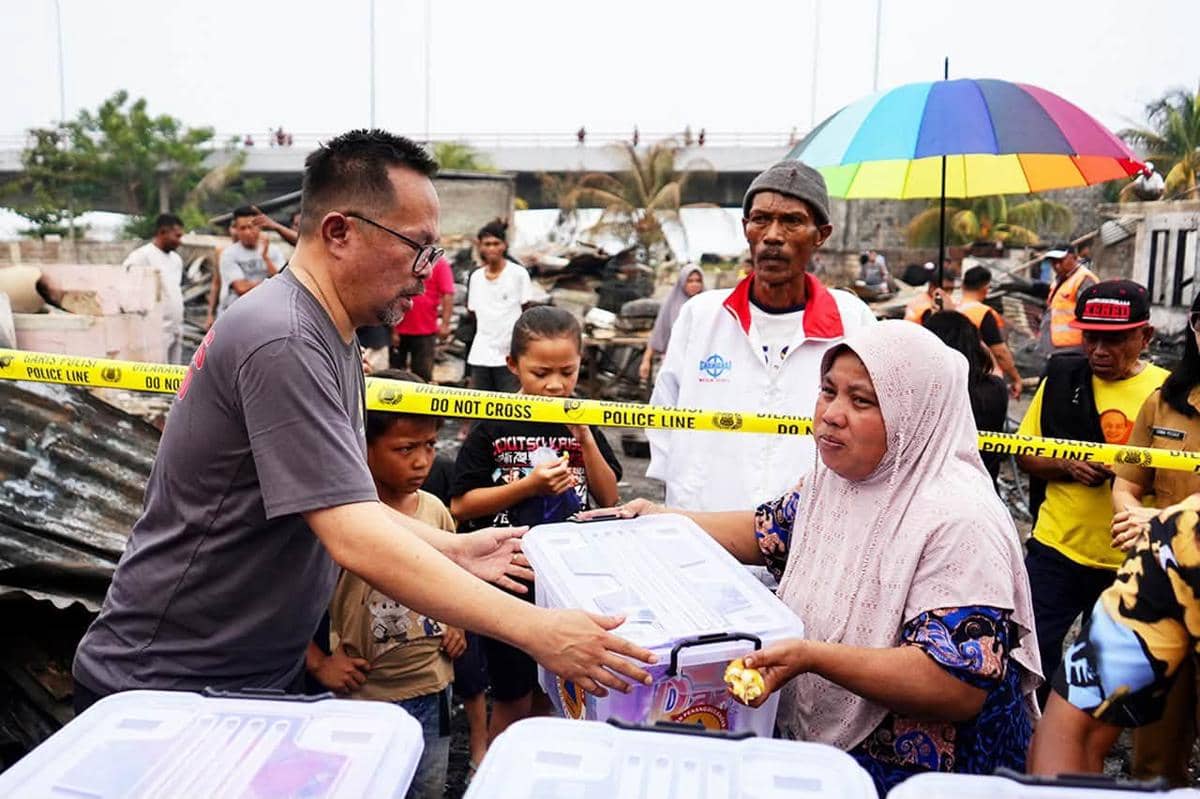 Wakil Wali Kota Manado Richard Sualang menyerahkan bantuan kepada warga korban kebakaran di Sindulang I.