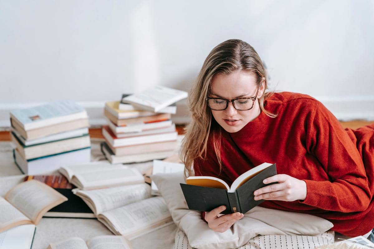potret seorang perempuan sedang membaca buku
