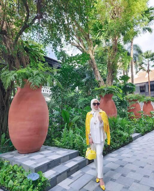 Syahrini tampil dengan OOTD liburan ke pantai, mengenakan busana santai bernuansa elegan di tepi laut.
