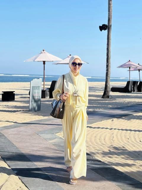 Syahrini mengenakan OOTD liburan pantai dalam unggahan Instagram @princessyahrini dengan latar suasana pesisir.