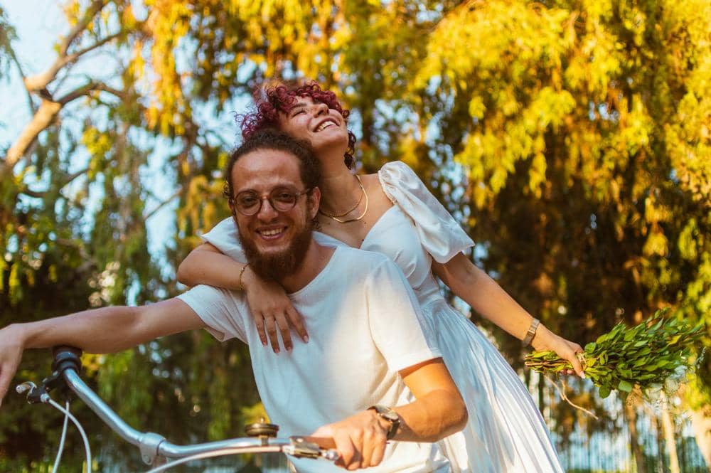 Perempuan dan laki-lakiberboncengan naik sepedq
