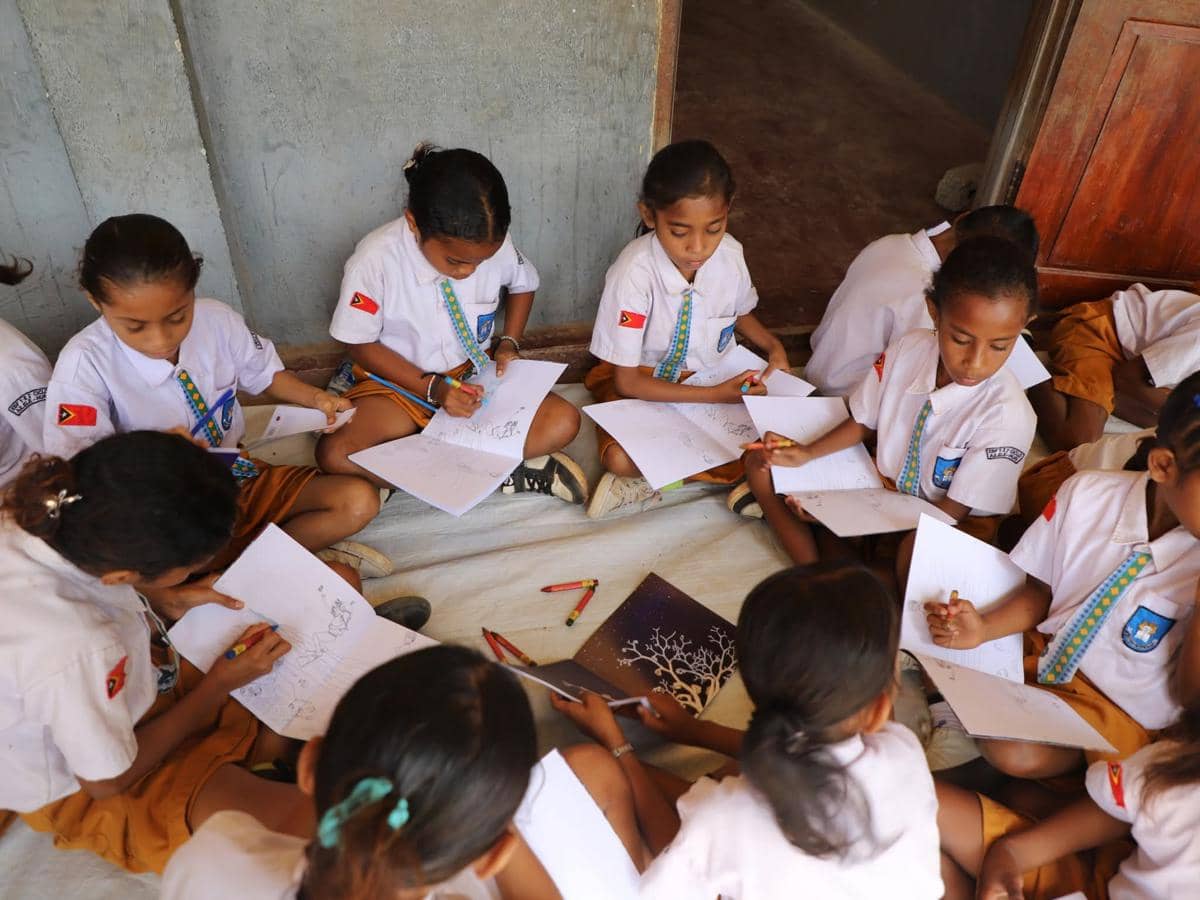 Seorang guru mengajar murid-murid di dalam ruang kelas sekolah di Timor Leste saat proses belajar berlangsung.