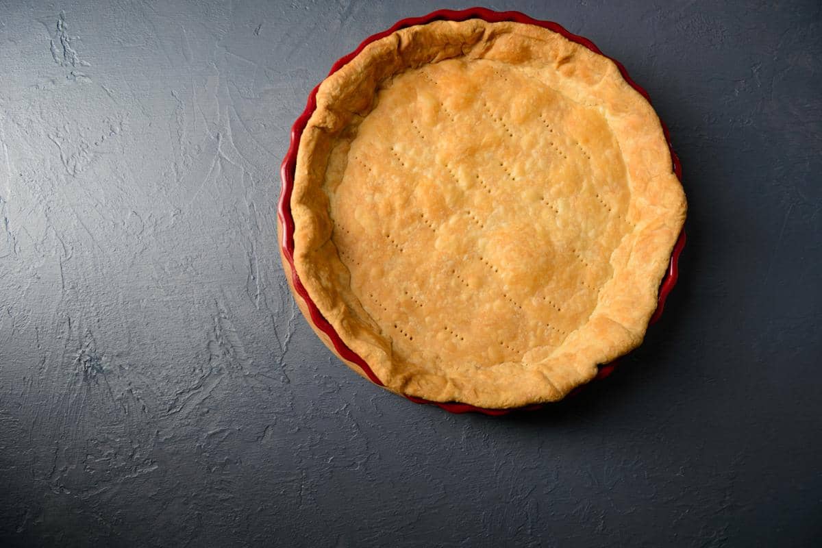 Ilustrasi kulit pie berwarna keemasan dengan tekstur renyah, siap diisi berbagai bahan makanan lezat.