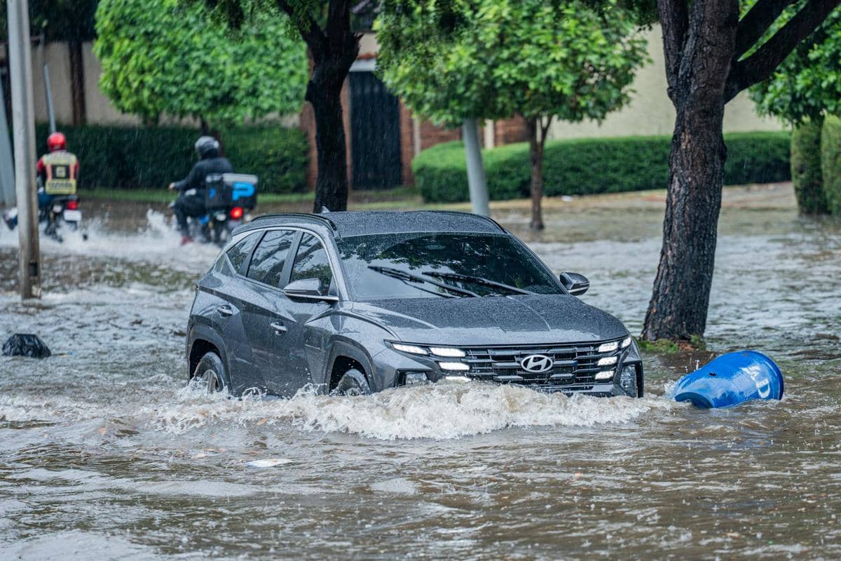 sebuah mobil melintas di jalan yang terendam banjir 