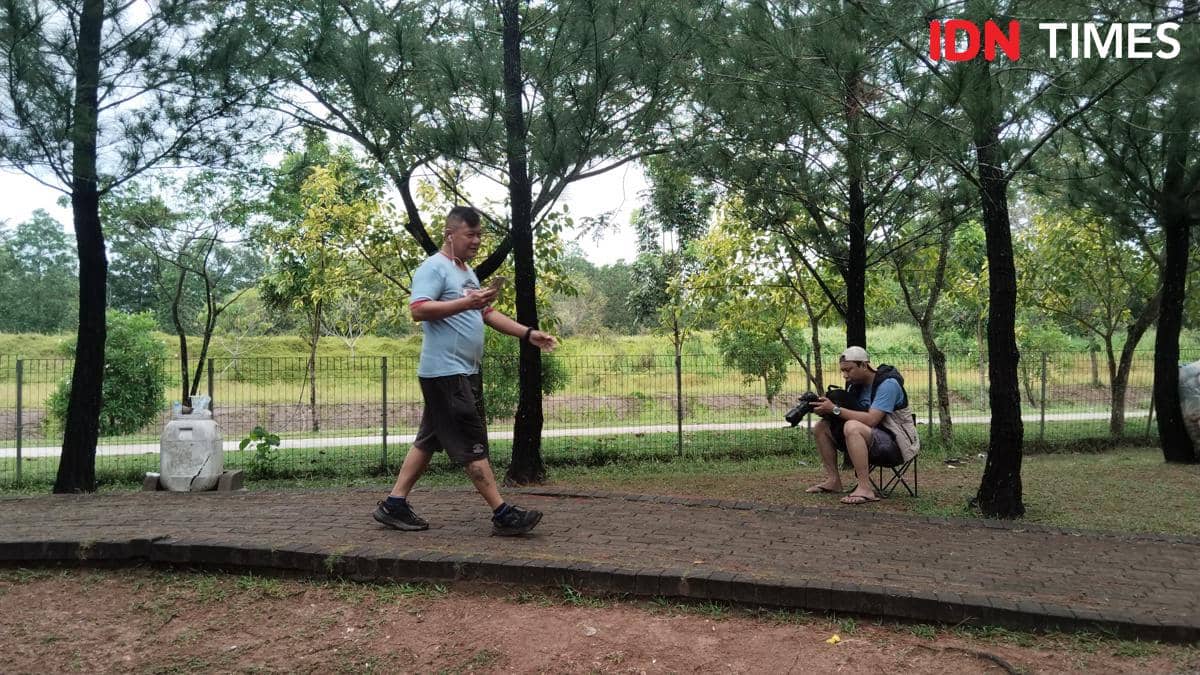 Aktivitas memotret para pelari di ruang publik oleh seorang street fotografer di Makassar. (IDN Times/Ashrawi Muin)