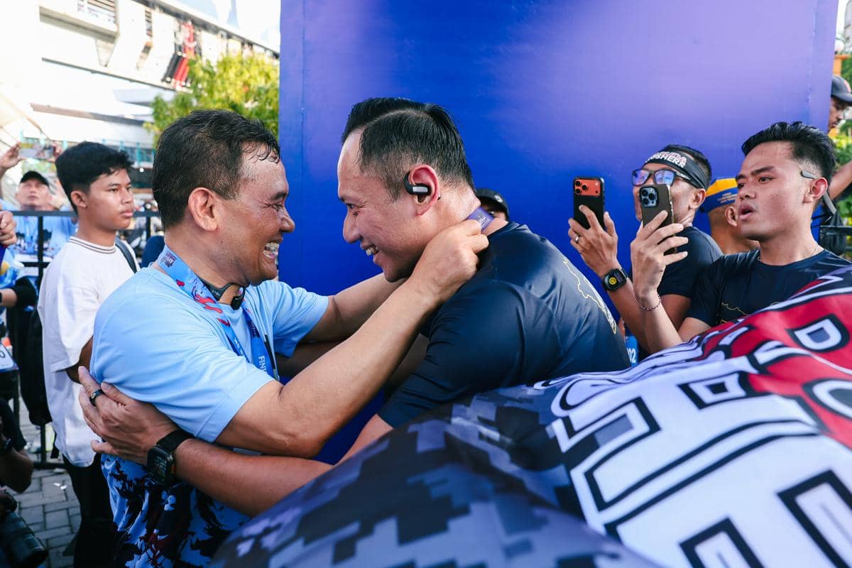 Ahmad Luthfi mengalungkan medali ke leher AHY dalam momen penyerahan medali pada sebuah acara bersama.
