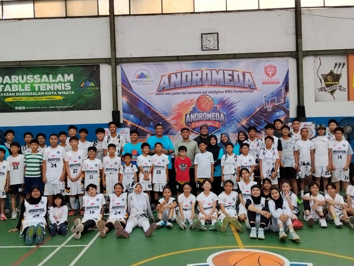 Para pemain Andromeda Basketball Club berpose bersama di lapangan, terinspirasi Hornbills yang menjuarai IBL.