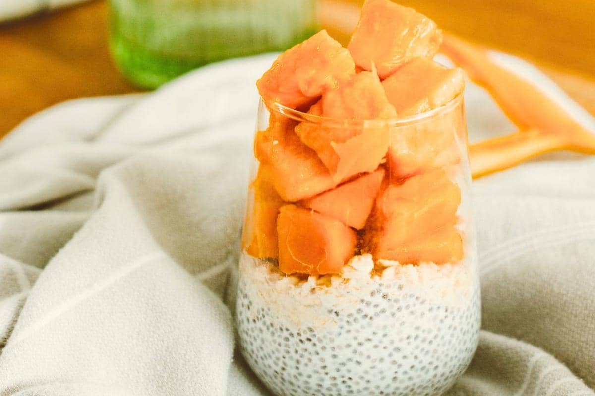 Ilustrasi mango bango, minuman berbahan mangga yang disajikan dalam gelas bersama potongan buah mangga segar.