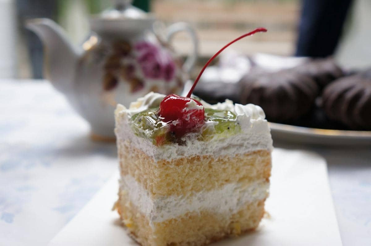 Kue putih berlapis dengan hiasan sederhana, disajikan sebagai ilustrasi white cake dalam latar yang bersih.