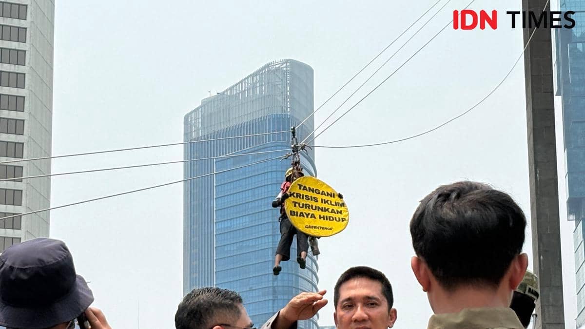 Aktivis Greenpeace usai pasang spanduk di Patung Tugu Selamat Datang, Bundaran Hotel Indonesia (HI), Jakarta Pusat, (20/10/2026) pagi. (IDN