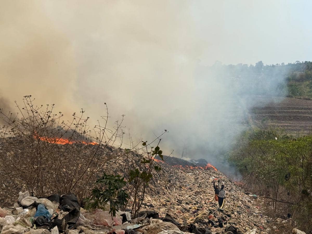 Petugas Damkar berupaya memadamkan api di TPA Supiturang, Malang, dengan menyemprotkan air ke lokasi kebakaran.