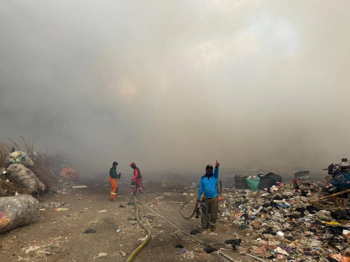 Petugas pemadam kebakaran berupaya memadamkan api di TPA Supiturang, Kota Malang, dengan penyemprotan air.