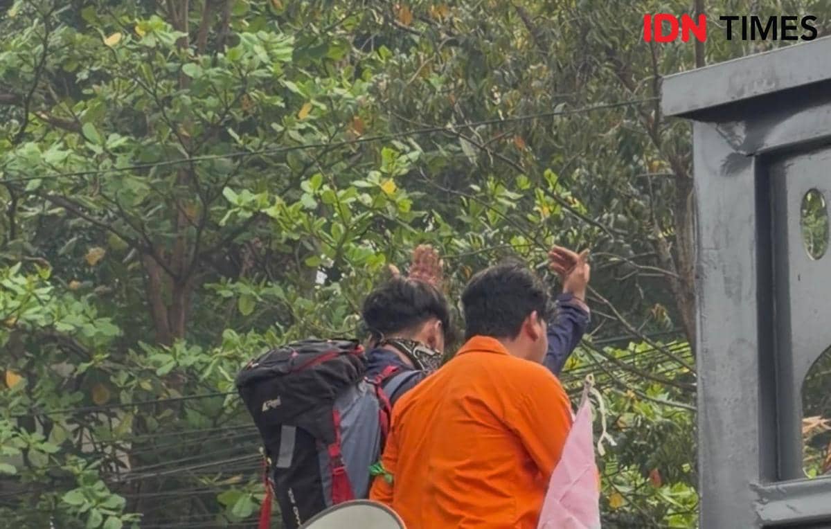 Aksi tetrikal mahasiswa berpura-pura menjadikan kantor gubernur sebagai tempat pendakian 