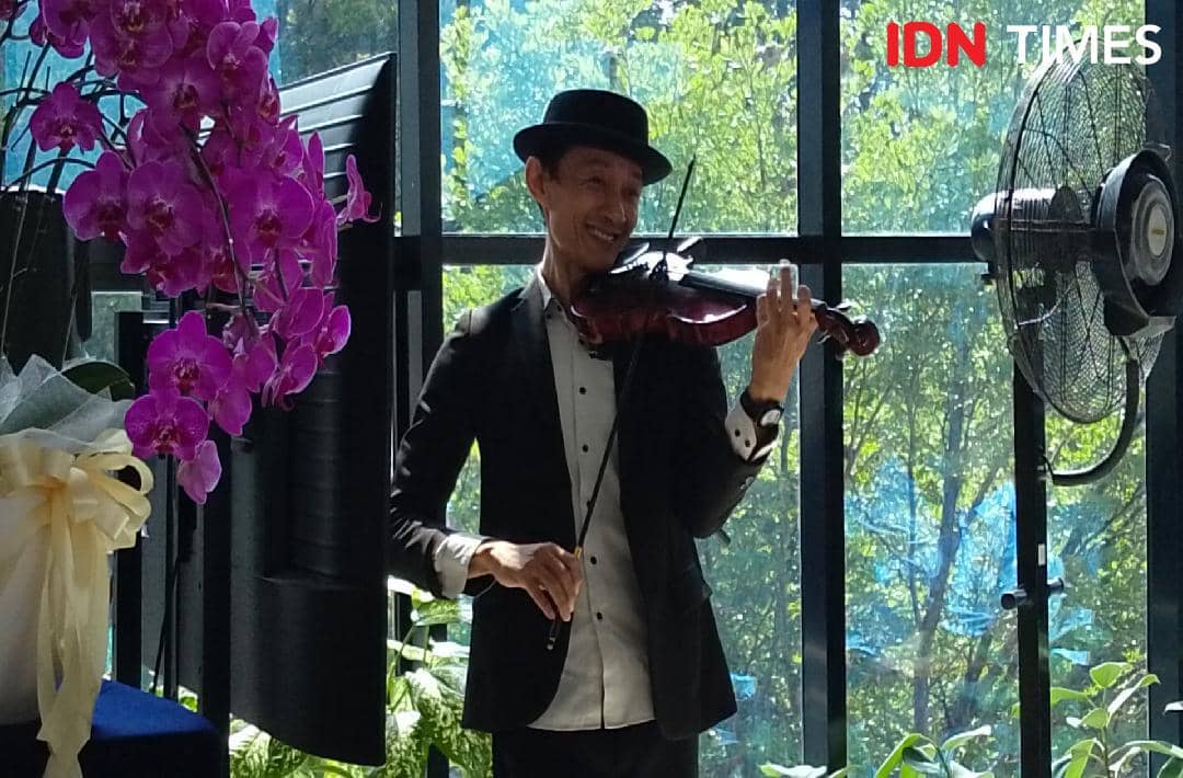 Seorang seniman biola Banyumas memainkan biola membawakan lagu Ditepinya Sungai Serayu dalam pertunjukan musik.