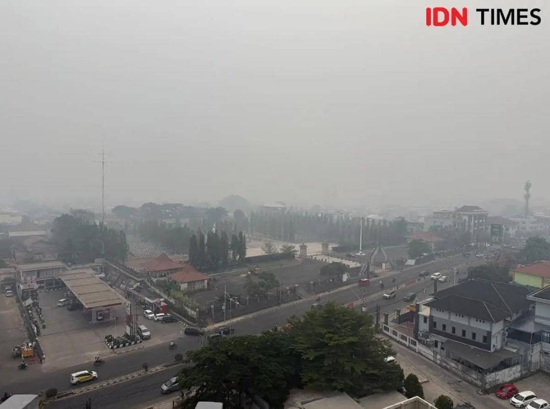 Kondisi kabut asap di kota Palembang yang tiba-tiba gelap ditutupi polusi kebakaran hutan dan lahan