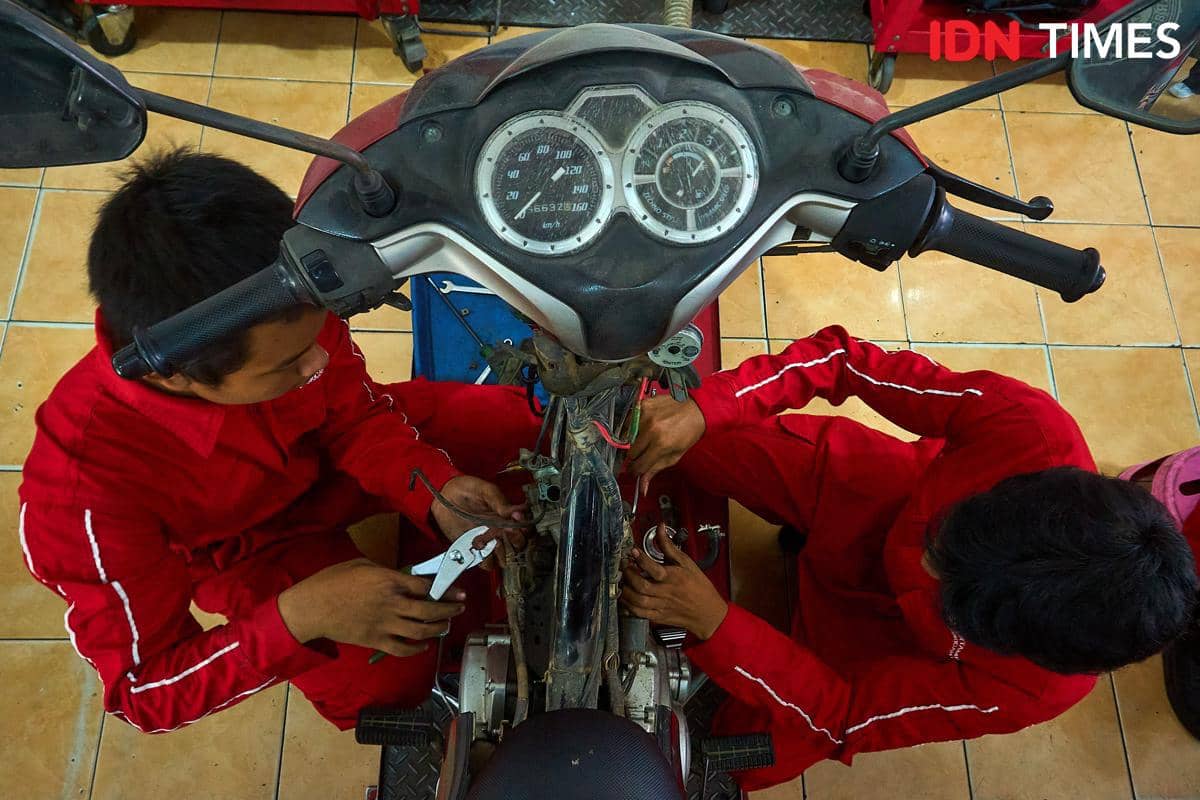 Sejumlah siswa bekerja sama memperbaiki sepeda motor pelanggan di bengkel Karya Speed, SMK Harapan Mulya, Kabupaten Kendal, Jawa Tengah, Rab