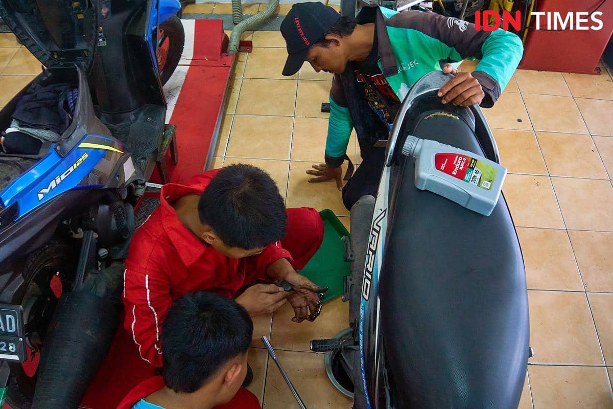 Para siswa menangani perawatan berkala sepeda motor pelanggan di area servis bengkel Karya Speed, SMK Harapan Mulya, Kabupaten Kendal, Jawa 