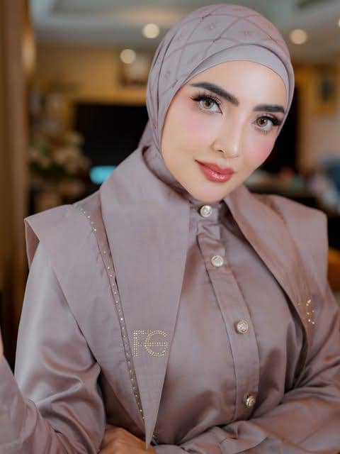 Ashanty tampil dengan riasan wajah glamor, alis tegas, bulu mata lentik, dan lipstik merah muda.