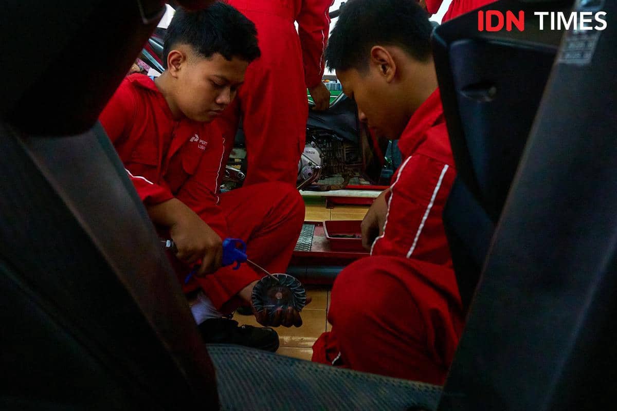 Sejumlah siswa bekerja sama memperbaiki sepeda motor pelanggan di bengkel Karya Speed, SMK Harapan Mulya, Kabupaten Kendal, Jawa Tengah, Rab
