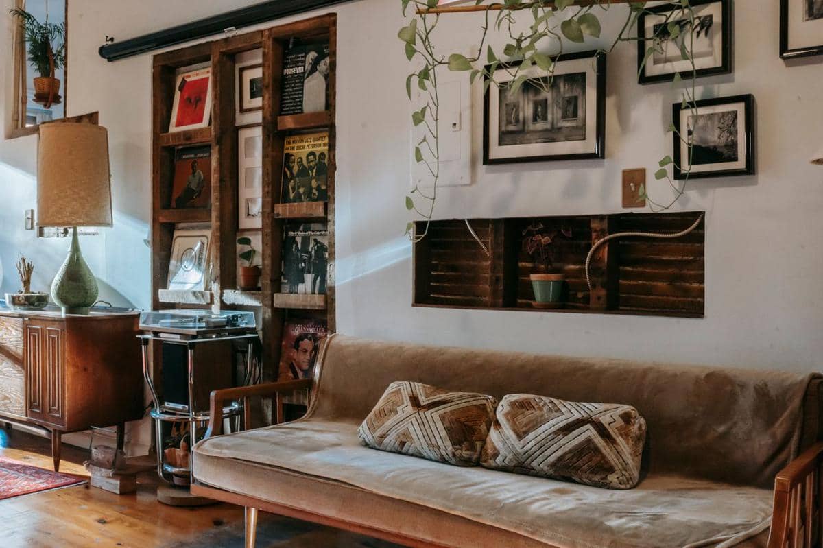 Ruang bergaya vintage dengan furnitur klasik, dinding berornamen, dan dekorasi bernuansa hangat di dalam rumah.