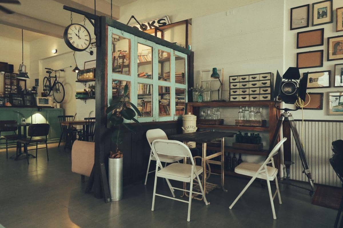 Ruang bergaya vintage dengan perabot klasik, pencahayaan hangat, serta dekorasi bernuansa nostalgia di dalam interior.