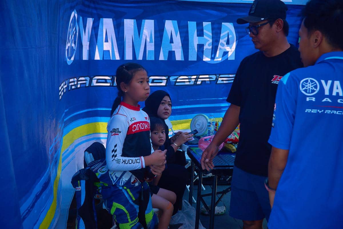 Pembalap cilik Hanin Dhiya Humaira (10) (kiri, mengenakan wearpack) menyimak arahan kru dan pendamping di bawah tenda tim pada rangkaian Fin
