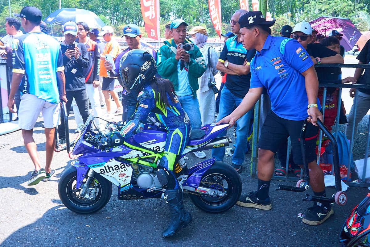 Sejumlah anggota kru membantu menyiapkan sepeda motor balap berkelir biru yang ditunggangi Hanin Dhiya Humaira (10) sebelum memasuki lintasa