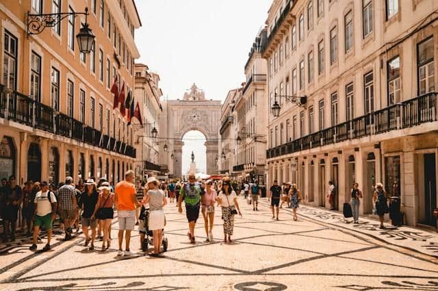 potret wisatawan berjalan di jalan dekat gedung, Lisbon, Portugal