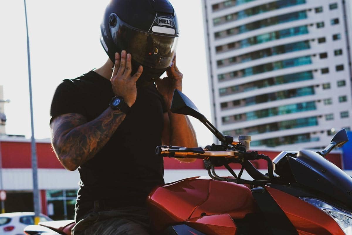 seroang pria memakai helm saat berkendara 