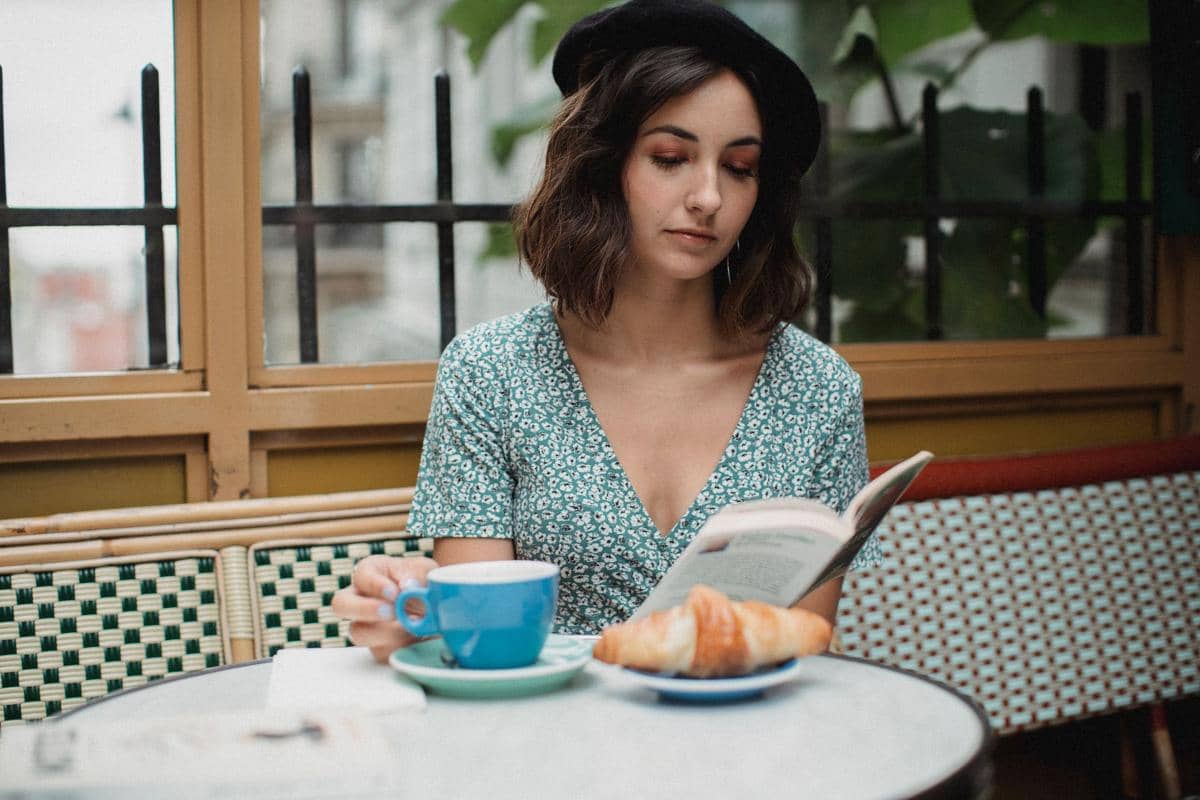 membaca buku di kafe 