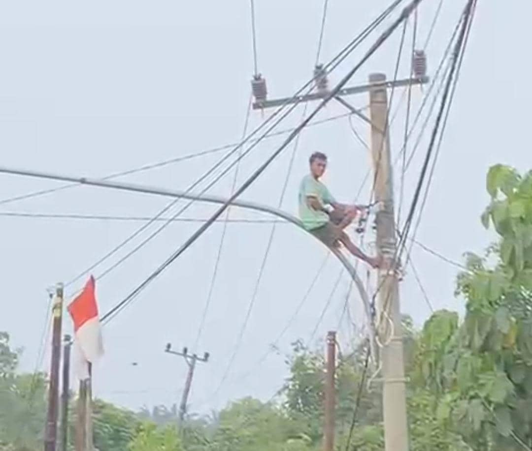 Seorang pria nekat memanjat tiang listrik di Bayung Lencir dalam aksi berbahaya di dekat jaringan listrik.