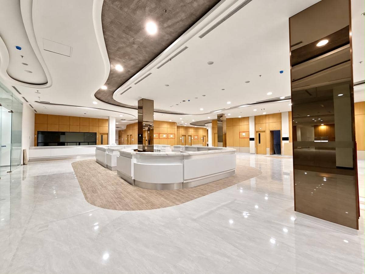 Tampak luar Gedung Siloam Sriwijaya, bangunan bertingkat dengan fasad modern dan area jalan di depannya.